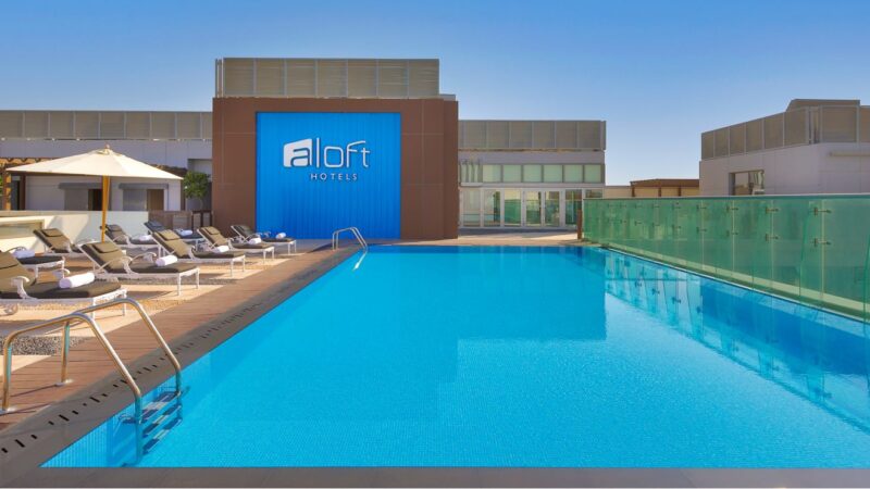 Trendy outdoor rooftop pool at Aloft Dubai Airport hotel.