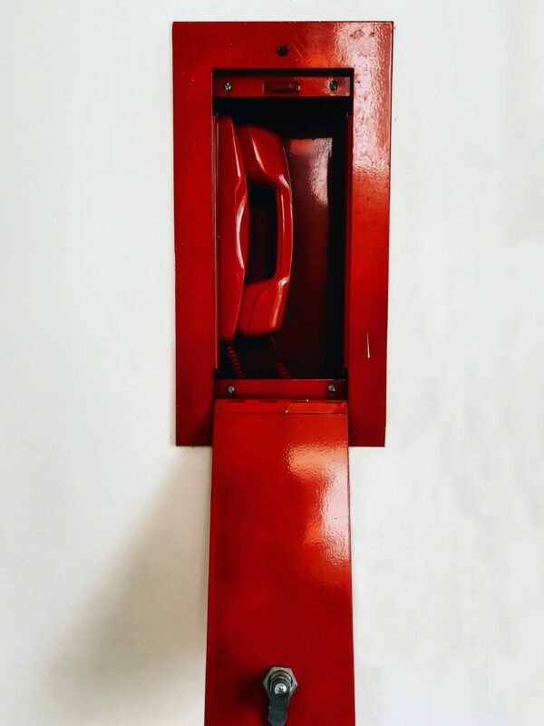 Red emergency telephone in a wall box, representing Plan B travel fixes.
